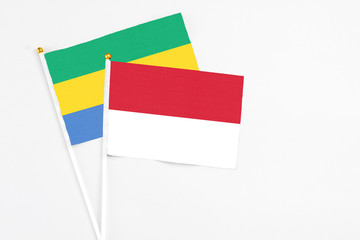 Indonesia and Gabon stick flags on white background. High quality fabric, miniature national flag....