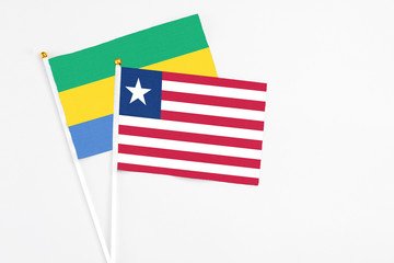 Liberia and Gabon stick flags on white background. High quality fabric, miniature national flag. Peaceful global concept.White floor for copy space.