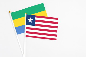 Liberia and Gabon stick flags on white background. High quality fabric, miniature national flag....