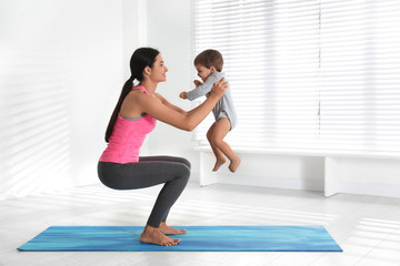 Young woman doing exercise with her son indoors. Home fitness