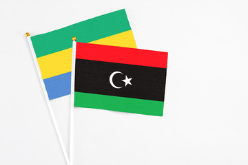 Libya and Gabon stick flags on white background. High quality fabric, miniature national flag....