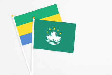 Macao and Gabon stick flags on white background. High quality fabric, miniature national flag....