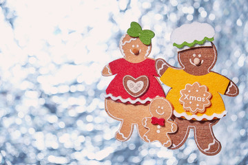 Christmas background with Christmas tree toys, three gingerbread men on a silver background, free space for text