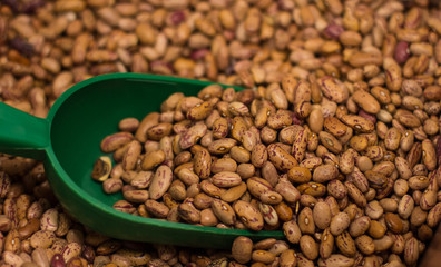 weight spoon in raw beans market counter background 