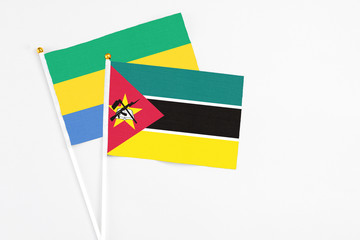 Mozambique and Gabon stick flags on white background. High quality fabric, miniature national flag....