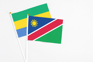 Namibia and Gabon stick flags on white background. High quality fabric, miniature national flag. Peaceful global concept.White floor for copy space.