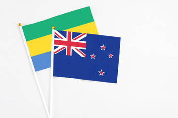 New Zealand and Gabon stick flags on white background. High quality fabric, miniature national...