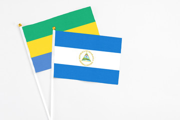 Nicaragua and Gabon stick flags on white background. High quality fabric, miniature national flag....