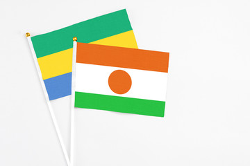 Niger and Gabon stick flags on white background. High quality fabric, miniature national flag....