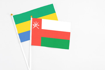 Oman and Gabon stick flags on white background. High quality fabric, miniature national flag....