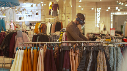 Man walks around the store wearing virtual reality glasses