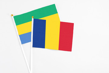 Romania and Gabon stick flags on white background. High quality fabric, miniature national flag....