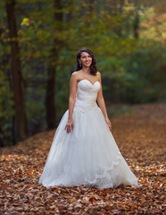 Obraz na płótnie Canvas Bride in white dress in the forest