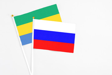 Russia and Gabon stick flags on white background. High quality fabric, miniature national flag....