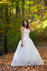 Obraz na płótnie Canvas Bride in white dress in the forest