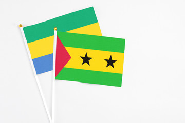 Sao Tome And Principe and Gabon stick flags on white background. High quality fabric, miniature national flag. Peaceful global concept.White floor for copy space.