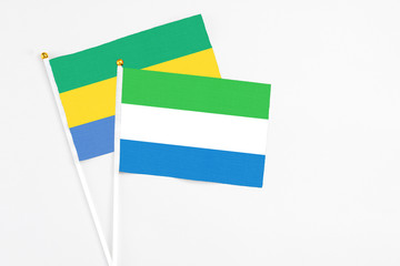 Sierra Leone and Gabon stick flags on white background. High quality fabric, miniature national...