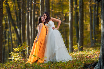 Obraz na płótnie Canvas Bride and bridesmaid in the forest