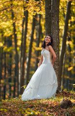 Bride in white dress in the forest