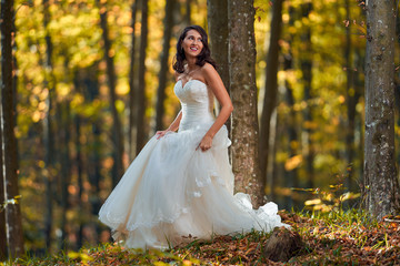 Bride in white dress in the forest