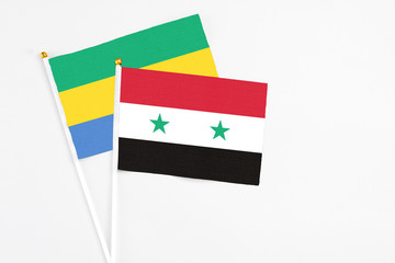 Syria and Gabon stick flags on white background. High quality fabric, miniature national flag....