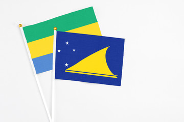 Tokelau and Gabon stick flags on white background. High quality fabric, miniature national flag....