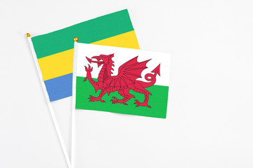 Wales and Gabon stick flags on white background. High quality fabric, miniature national flag....