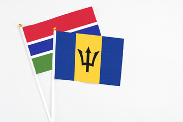 Barbados and Georgia stick flags on white background. High quality fabric, miniature national flag. Peaceful global concept.White floor for copy space.