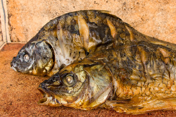 Hot smoked carp on old wooden boards.