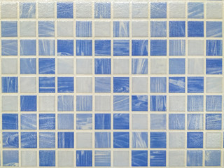 Small bathroom or kitchen tiles in blue and white colors making an interesting textured pattern of ceramics on the wall or floor