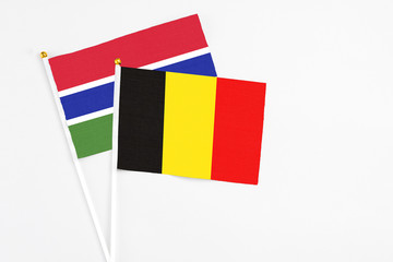 Belgium and Georgia stick flags on white background. High quality fabric, miniature national flag. Peaceful global concept.White floor for copy space.