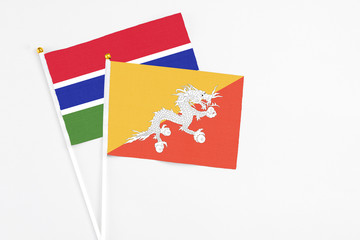 Bhutan and Georgia stick flags on white background. High quality fabric, miniature national flag. Peaceful global concept.White floor for copy space.