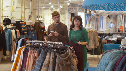 Girl shows her boyfriend the clothes she has chosen