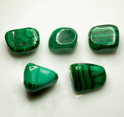 Natural polished green malachite on the white background