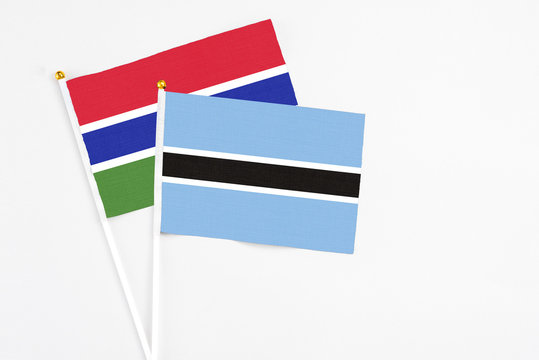 Botswana and Georgia stick flags on white background. High quality fabric, miniature national flag. Peaceful global concept.White floor for copy space.