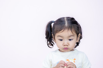A little girl with a smiling face, two and a half years old, wearing a white shirt