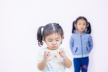 A little girl with a smiling face, two and a half years old, wearing a white shirt