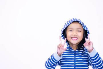 A little girl with a smiling face, aged three and a half wearing a blue sweate