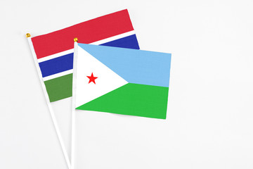 Djibouti and Georgia stick flags on white background. High quality fabric, miniature national flag. Peaceful global concept.White floor for copy space.