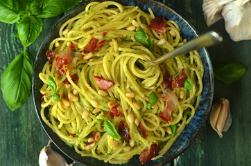 Spaghetti with basil pesto in a rustic bowl
