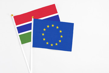 European Union and Georgia stick flags on white background. High quality fabric, miniature national flag. Peaceful global concept.White floor for copy space.