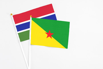 French Guiana and Georgia stick flags on white background. High quality fabric, miniature national flag. Peaceful global concept.White floor for copy space.