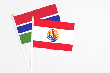 French Polynesia and Georgia stick flags on white background. High quality fabric, miniature national flag. Peaceful global concept.White floor for copy space.