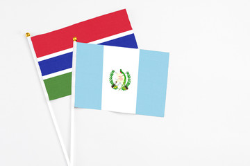 Guatemala and Georgia stick flags on white background. High quality fabric, miniature national flag. Peaceful global concept.White floor for copy space.