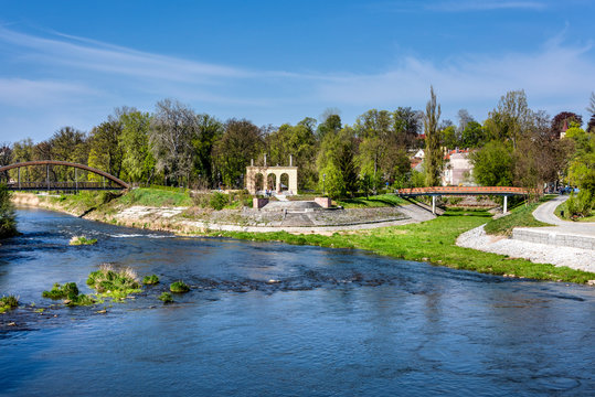 Poland, Guben, Gubin: Neisse river with Polish riverside near city center at German Polish border seen from Neisse bridge with apartment houses, green trees, public park and blue sky.