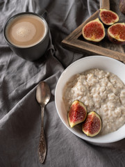Healthy breakfast in bed. Coffee, porridge with figs, on a rustic wooden board. Clean food, alkaline diet, 