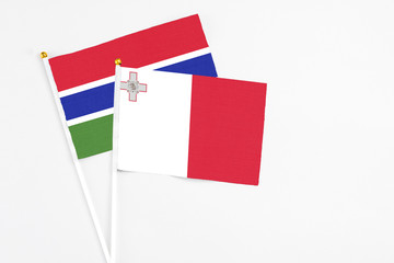 Malta and Georgia stick flags on white background. High quality fabric, miniature national flag. Peaceful global concept.White floor for copy space.