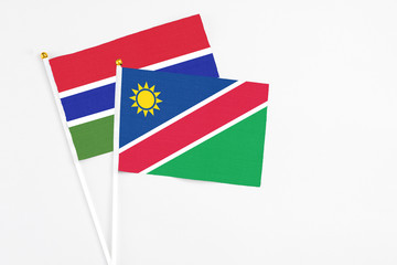 Namibia and Georgia stick flags on white background. High quality fabric, miniature national flag. Peaceful global concept.White floor for copy space.
