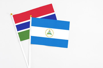 Nicaragua and Georgia stick flags on white background. High quality fabric, miniature national flag. Peaceful global concept.White floor for copy space.