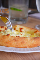 Khachapuri with cheese, close-up. There is a khachapuri. 